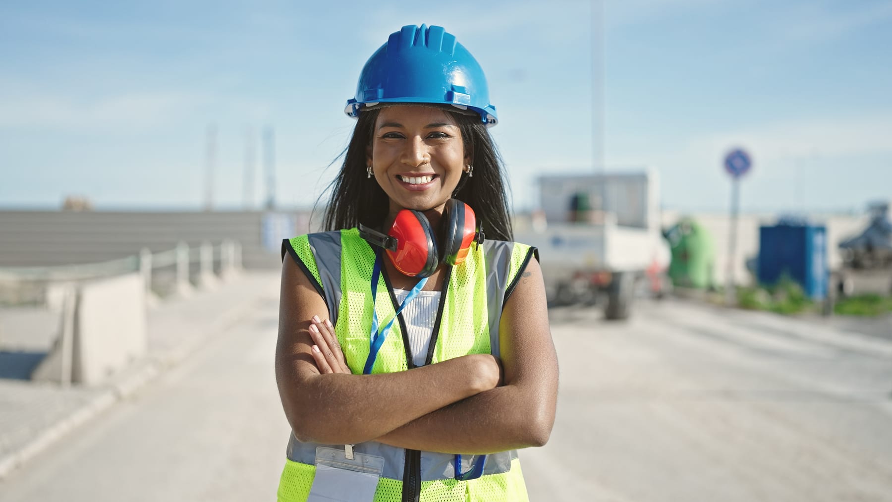 A site supervisor in a hard hat and hi-vis on a working site